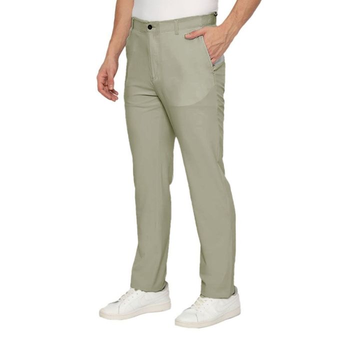 Person wearing light green pants and white sneakers on a white background